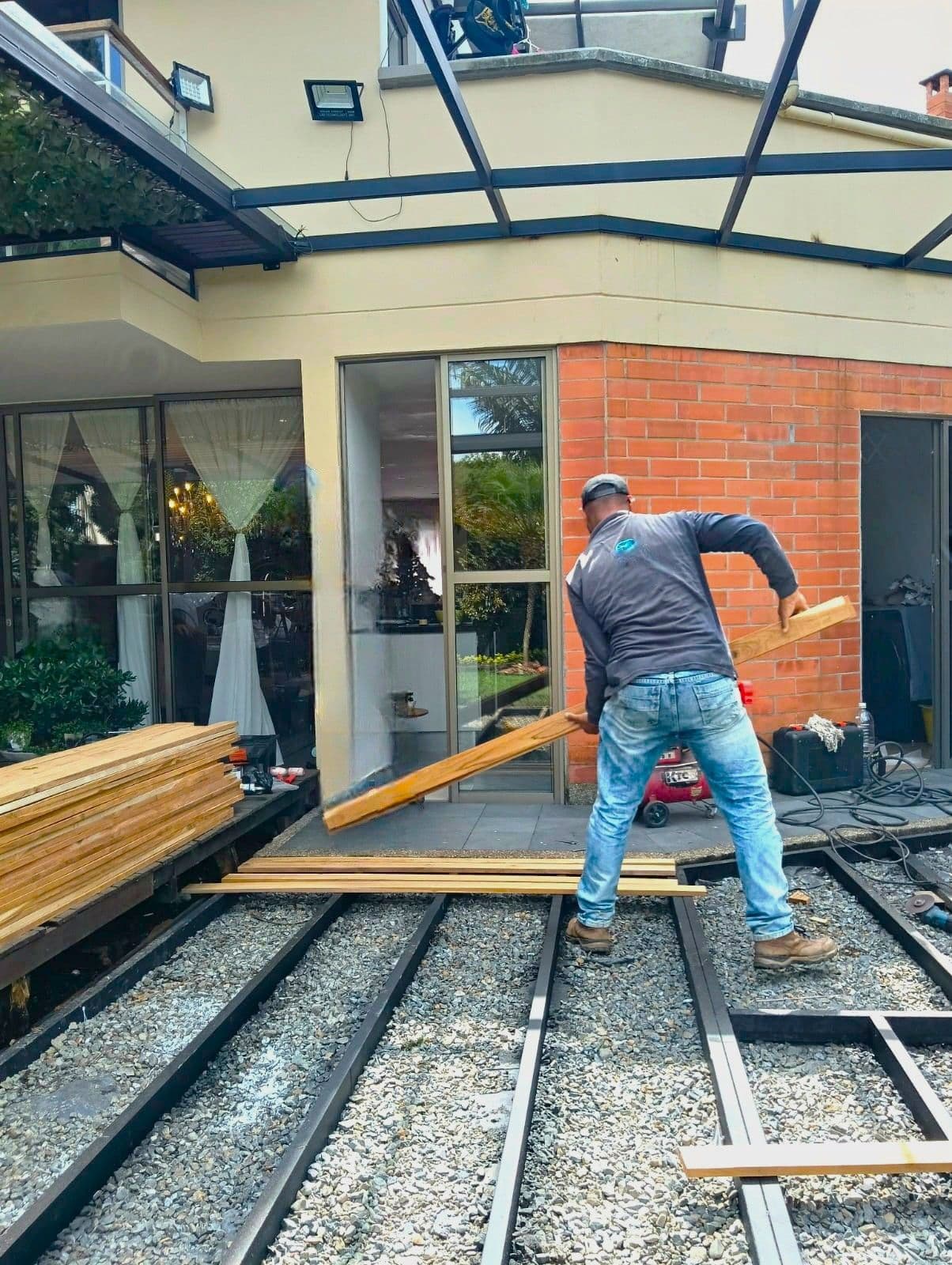 Pérgola con cubierta de vidrio y deck en madera