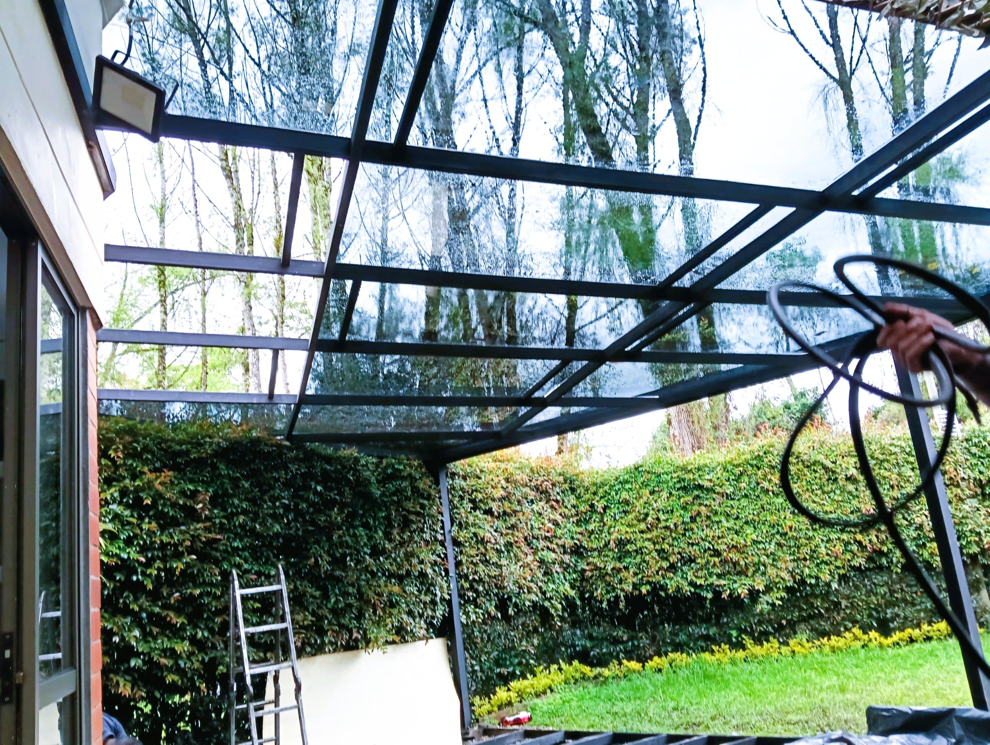 Pérgola con cubierta de vidrio y deck en madera