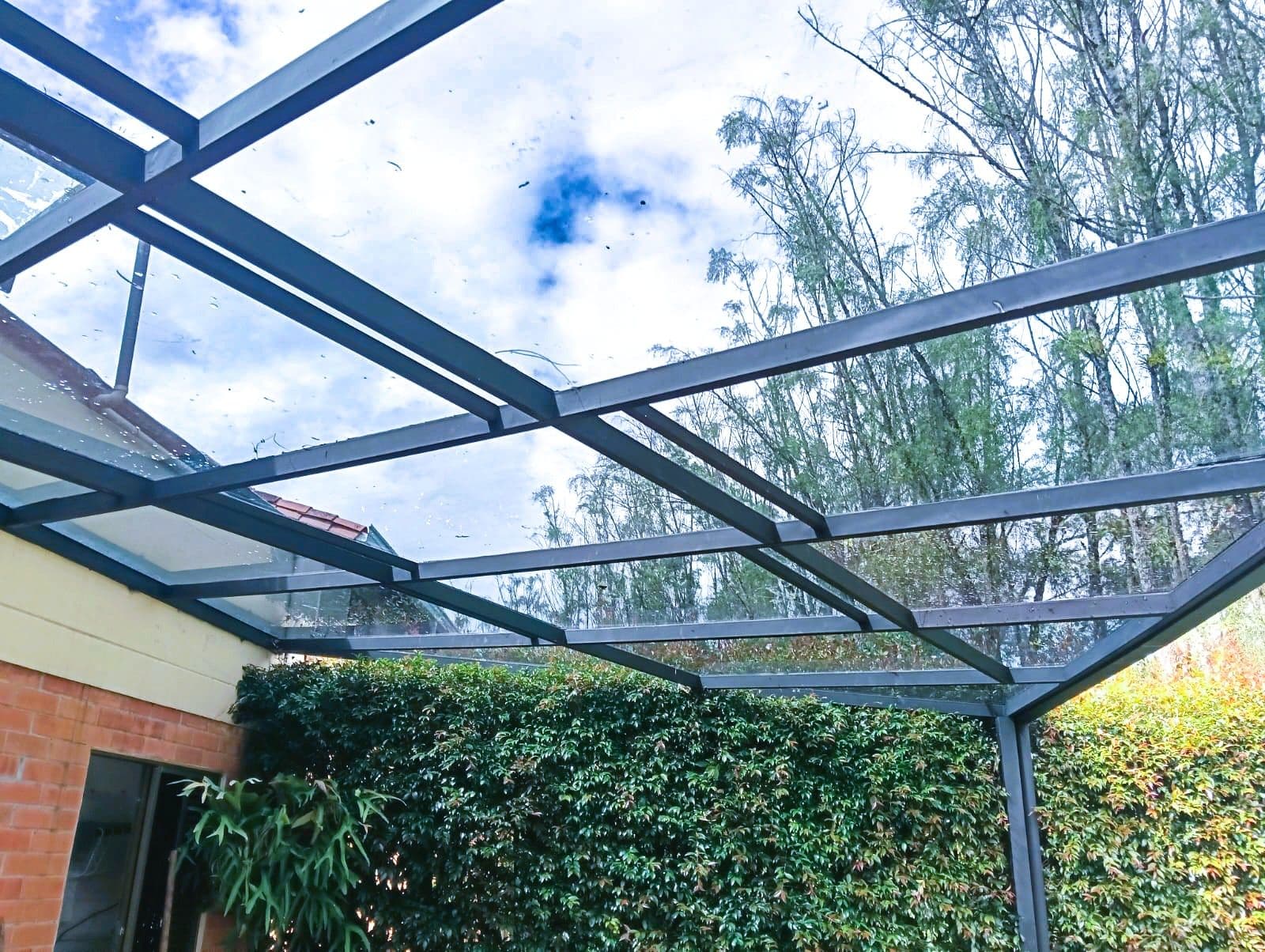 Pérgola con cubierta de vidrio y deck en madera
